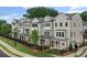 Row of newly constructed townhomes with varied neutral siding, manicured lawns, and black metal fences at 1980 Flying Scotsman Dr # 10, Kennesaw, GA 30144