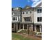 View of newly built townhomes features white siding and stone accents with dark metal railings and black windows at 1980 Flying Scotsman Dr # 10, Kennesaw, GA 30144