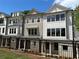 Beautiful exterior of townhomes with black metal fencing, light colored siding, and stone foundations at 1980 Flying Scotsman Dr # 10, Kennesaw, GA 30144