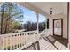 Spacious front porch with white railings and a red door at 121 Rachel Blvd, Temple, GA 30179