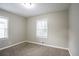 Bedroom with neutral walls, plush carpet, and natural light from two windows at 3234 Bluebird Ln, Decatur, GA 30032