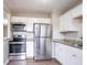 Bright kitchen featuring granite countertops, stainless steel appliances, and white cabinetry at 3234 Bluebird Ln, Decatur, GA 30032
