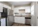 Bright kitchen featuring granite countertops, stainless steel appliances, and white cabinetry at 3234 Bluebird Ln, Decatur, GA 30032