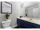 Well-lit half bathroom with white vanity, blue cabinets, and decorative mirror at 1634 Ponce De Leon Ne Ave # 503, Atlanta, GA 30307