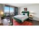 Bedroom with green velvet bed, city views, and colorful rug at 2660 Peachtree Rd # 27E, Atlanta, GA 30305