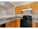 Kitchen with wood cabinets, black appliances, and granite counters at 3607 Ginnis Sw Dr # 7, Atlanta, GA 30331