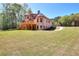 Expansive backyard with a two-story home featuring a wooden deck and lush greenery at 43 Iroquois Ct, Covington, GA 30014