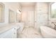 Bathroom with soaking tub, marble accent wall and double vanity at 43 Iroquois Ct, Covington, GA 30014