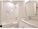 White bathroom features a tub-shower combo with a tile surround, a recessed shelf, and a sink with vanity at 43 Iroquois Ct, Covington, GA 30014