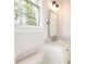 Bright bathroom features white marble countertops, a modern mirror, stylish lighting, and a large window at 43 Iroquois Ct, Covington, GA 30014