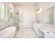 Modern bathroom featuring a soaking tub, glass-enclosed shower, and dual vanities, creating a spa-like experience at home at 43 Iroquois Ct, Covington, GA 30014