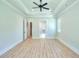 Spacious bedroom featuring wood floors, tray ceiling, ceiling fan, and an ensuite bathroom at 43 Iroquois Ct, Covington, GA 30014