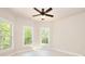 Sunlit bedroom with many windows and a modern ceiling fan offering refreshing views of the lush green foliage at 43 Iroquois Ct, Covington, GA 30014