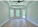 Bright bedroom features wood floors, tray ceiling, a ceiling fan, and access to a private deck at 43 Iroquois Ct, Covington, GA 30014