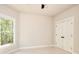 Neutrally decorated bedroom boasts a ceiling fan, a large window showcasing a lush view, and a double door closet at 43 Iroquois Ct, Covington, GA 30014