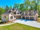 Stunning two-story brick home boasts a three-car garage, a manicured lawn, and a welcoming entrance at 43 Iroquois Ct, Covington, GA 30014