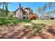 Expansive lawn showcasing a two-story brick home, complete with an elevated deck and lush greenery at 43 Iroquois Ct, Covington, GA 30014