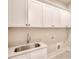 Laundry room with a stainless steel sink and white cabinets at 43 Iroquois Ct, Covington, GA 30014