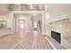 Open living area with hardwood floors, stone fireplace, and access to kitchen, dining, and staircase at 43 Iroquois Ct, Covington, GA 30014