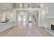 Open concept living room boasts a stone fireplace, staircase, and modern kitchen with wood floors throughout at 43 Iroquois Ct, Covington, GA 30014