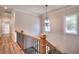 Staircase featuring hardwood floors, oak railings, and a modern light fixture at 43 Iroquois Ct, Covington, GA 30014