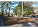 Landscaped front yard with mature trees and a spacious driveway at 9935 La View Cir, Roswell, GA 30075