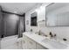 Modern bathroom with double vanity, grey tile, and tub at 1506 Avon Sw Ave, Atlanta, GA 30311