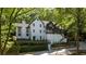 White two-story house with a modern design, surrounded by trees and landscaping at 6305 River Chase Cir, Atlanta, GA 30328