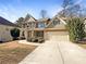 Two-story house with brick and siding, attached garage, and manicured landscaping at 7227 Parks Trl, Fairburn, GA 30213