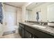 Bathroom showcasing dual sinks with granite countertops, a shower/tub combo, and dark cabinetry at 2496 Osceola Rd, Lithonia, GA 30058