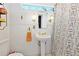 Stylish bathroom featuring white tile, a pedestal sink, gold fixtures, and a patterned shower curtain at 3532 South Fulton Ave, Hapeville, GA 30354