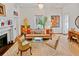 Bright living room with unique decor, patterned rug, fireplace and comfortable seating at 3532 South Fulton Ave, Hapeville, GA 30354