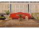 Stylish outdoor living space with vibrant orange sofa, patterned rug, and chic seating arrangements at 3532 South Fulton Ave, Hapeville, GA 30354