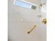 Bright white tiled shower featuring gold grab bar and a shower head at 3532 South Fulton Ave, Hapeville, GA 30354