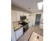 Galley kitchen with white cabinets and modern appliances at 733 Exchange Mill, Dacula, GA 30019