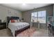 Neutral bedroom with a large window and dark furniture set against soft colored walls and plush carpet at 130 Bingley Ct, Covington, GA 30016