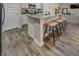 Kitchen island with barstool seating, granite countertop, and modern gray wood flooring at 130 Bingley Ct, Covington, GA 30016