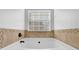A close up view of a tub with tile surround and window at 5030 Mundy Dr, Cumming, GA 30028
