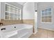 A bathroom featuring a tub with tile surround and window at 5030 Mundy Dr, Cumming, GA 30028