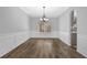 Dining room with hardwood floors, chair rail, and a modern chandelier over a large window at 5030 Mundy Dr, Cumming, GA 30028