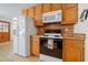 Eat-in kitchen with light wood cabinets and white appliances and tile floors at 175 Highland Cir, Mcdonough, GA 30253
