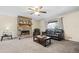 Carpeted living room featuring a stone fireplace and a ceiling fan at 175 Highland Cir, Mcdonough, GA 30253