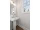 Small powder room with pedestal sink and window at 1979 Flying Scotsman Dr # 16, Kennesaw, GA 30144