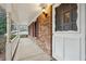 Covered porch with brick columns and a white door at 2077 Carthage Rd, Tucker, GA 30084