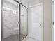 Modern tiled shower featuring frameless glass door and built-in shower caddy at 333 Gardens Of Harmony Dr, Canton, GA 30115