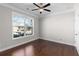 Bright bedroom featuring a ceiling fan, large window, and hardwood floors for a warm ambiance at 333 Gardens Of Harmony Dr, Canton, GA 30115