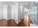 Hallway with hardwood floors, white trim, and stylish wall paneling, leading to various rooms at 333 Gardens Of Harmony Dr, Canton, GA 30115