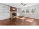 Inviting living room featuring a stone fireplace, built-in shelving, and hardwood floors at 333 Gardens Of Harmony Dr, Canton, GA 30115