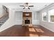 Bright living room with a stone fireplace flanked by built-in shelving, hardwood floors, and large windows for natural light at 333 Gardens Of Harmony Dr, Canton, GA 30115