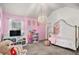 Charming bedroom featuring pink walls, gray carpet, unique chandelier, and a four-poster bed at 2625 Lake Erma Dr, Hampton, GA 30228